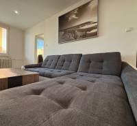 A bright living room with a comfortable sofa and a large window in a three-room apartment.