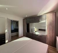 A bedroom with a built-in wardrobe and flowing natural light in a 3-room apartment.