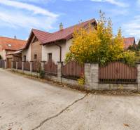A family house on Košariská Street in Rovinka with a brick roof and fence.