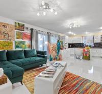 Colorful living room in a family house with a sofa, an armchair, and art on the walls.