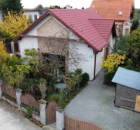 A family house on Košariská Street in Rovinka with a red roof and a garden full of greenery.