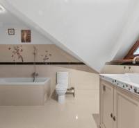 A bathroom in a family house with a bathtub, toilet, and decorative stickers on the walls.