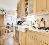 A kitchen in a 3-room apartment with a wooden decor and a spacious work surface.