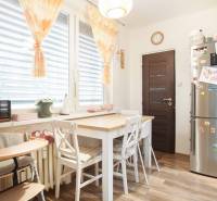 Dining room with a kitchen table, chairs, and a floor with a wooden decor, 3-room apartment.