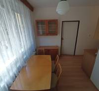 Dining area in a 2-room apartment with wooden floor decor and curtains.