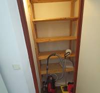 Storage space with shelves and a vacuum cleaner in a 2-room apartment.