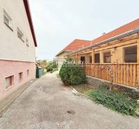 A courtyard with a pergola at hotels and guesthouses in Podhájska, with a stone pathway and garden.