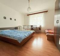 A room with a double bed, a single bed, a wardrobe, and a floor with a wooden decor in hotels and guesthouses.