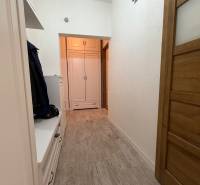 A narrow hallway in a 2-room apartment with storage space and a built-in wardrobe.