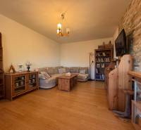Living room with a sofa, wood-decor floor, bookshelf, and a TV on the wall.