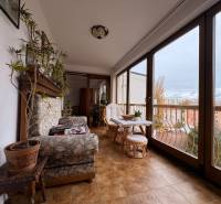 A spacious balcony in a 5 or more room apartment with large windows and cozy seating.