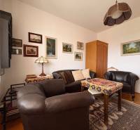 A room of a five or more-bedroom apartment with leather furniture and a floor with a wooden decor.