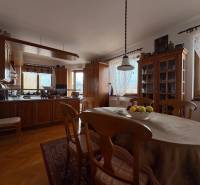 A kitchen in a 5 or more room apartment with a dining table and a wooden decor floor.