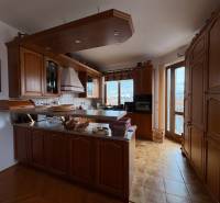 A kitchen in a 5 or more room apartment with built-in wooden cabinets and a floor with a wood decor.