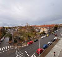 A view of the street with cars and buildings in Komárno, near a 5 or more room apartment.