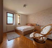 A room with a bed and a chair in a 5 or more room apartment. Floor with wood decor.