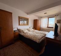 A bedroom in a 5 or more room apartment with carpet and wooden cabinets.