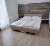 A bedroom in a cabin with a double bed, wooden wall decor, and light flooring.