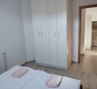 A bedroom in a cottage with a white wardrobe and a wooden decor floor.