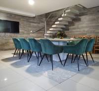Dining table with turquoise chairs on a cottage floor with wooden decor.