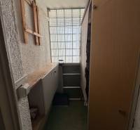 Storage space in a 3-room apartment with shelves and a glass wall.