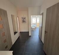 Entrance hallway in a 3-room apartment with dark flooring and light walls.