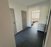 Entrance hallway in a 3-room apartment with dark tiles and light doors.