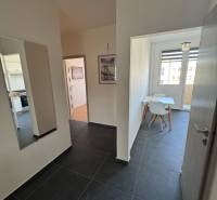 A hallway with dark tiles and a dining room in a 3-room apartment.