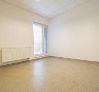 Empty office with a window, radiator, and floor.