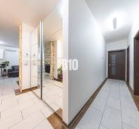 Hallway of a family house with tiles and a mirrored wall.