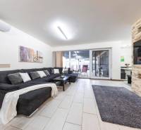 Living room of a family house with a sofa, fireplace, and sliding doors to the terrace.