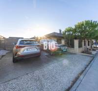 The courtyard of a family house in Most pri Bratislave with parking spaces and parked cars.