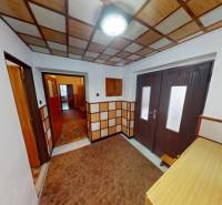 A hallway in a family house, walls and floor covered with wooden decor.