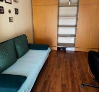 A room in a 3-room apartment with a wood-patterned floor and built-in wardrobes.