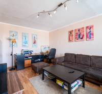 Living room in a 3-room apartment with a couch, table, and floor with a wooden decor.