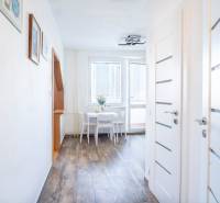 A hallway with wooden decor and a dining table in a 3-room apartment, luminous interior doors.