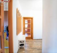 A hallway with a coat rack, a shoe cabinet, and a floor with a wooden decor in a 3-room apartment.