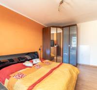 A bedroom with a large bed, a built-in wardrobe, and a wooden decor floor in a 3-room apartment.