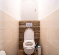 Bathroom with toilet and wooden decor flooring in a 3-room apartment.