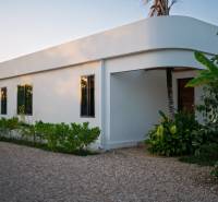 Construction of houses in Paje, Unguja South Region, with greenery around the white structure.