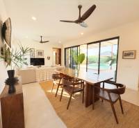 Interior with a dining table, wood-patterned flooring, and large glass doors, Home construction.