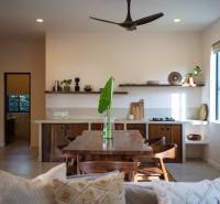 Interior of a kitchen with a wooden dining table, chairs, and shelves in the area of Home Construction.