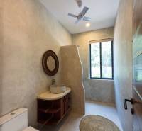 Bathroom with a sink, round rug, and fan. House construction.