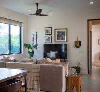 Interior with a sofa, television, and wooden furniture under construction of houses.