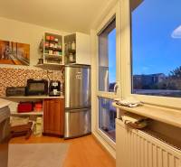 A kitchen in a 3-room apartment with a wooden decor floor and mosaic tiles.