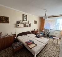 A room in a 3-room apartment with a crib, carpet, and furniture, decorations on the walls.