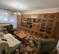 Living room in a 3-room apartment with a wooden wall unit and green furniture.