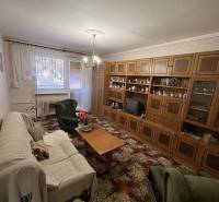 Living room in a 3-room apartment with a wooden wall unit and comfortable seating.
