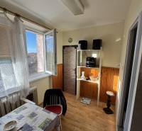 Dining room in a 3-room apartment with a wood-patterned floor and an open window.