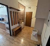 Interior of a 3-room apartment with a wooden decor floor and a wall-mounted coat rack.